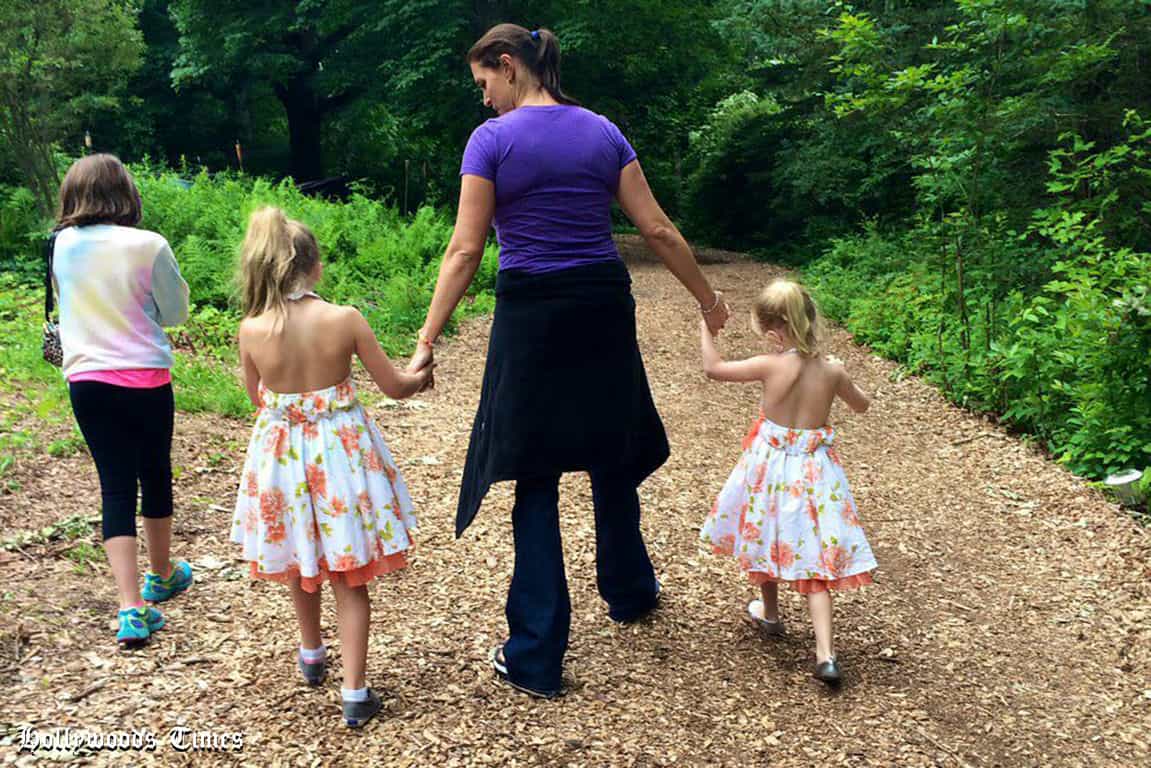 Aurora, Murphy and Vaughn holding hands on a morning hike with her mother